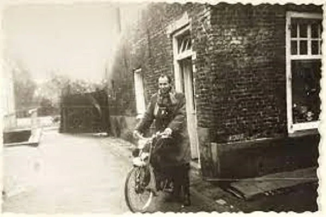 man op bromfiets bij oud brabants huis Kempenmuseum Eersel